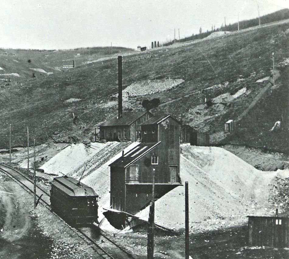 Cripple Creek District Railway Trolley seen passing the ore house of the Chicago Tunnel in Poverty Gulch, taken no later than summer of 1899. This due to this picture appeared in "The Engineering Magazine" for September 1899.
   This section of track in Poverty Gulch was built in 1897 (between April and December). Track abandoned 1903, grade here is 7.5%!!