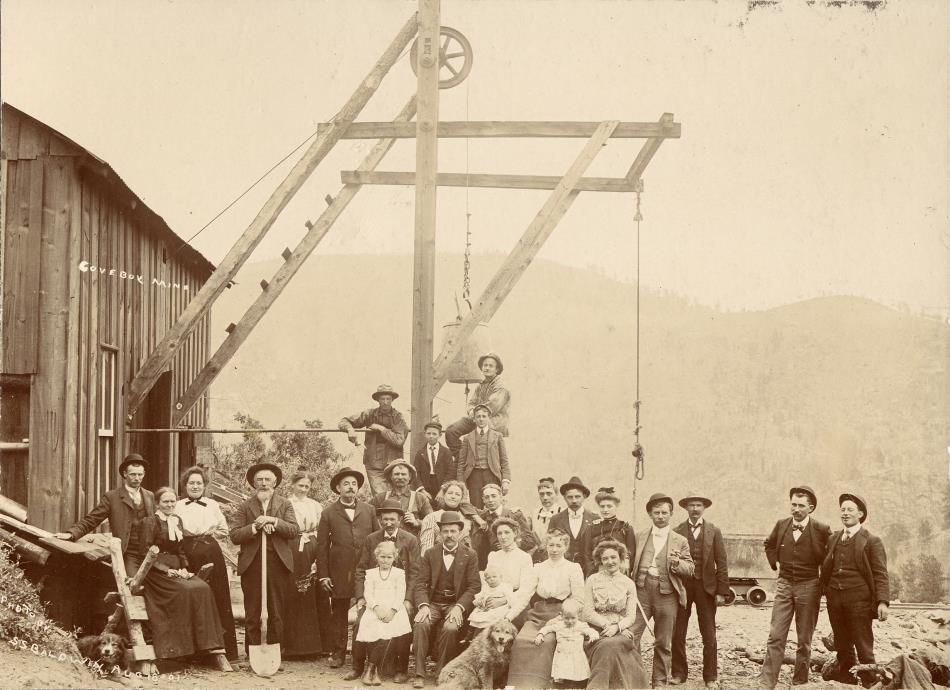 A view of a head frame and part of a hoist house, with many people of all types posing at the head frame. All these people staked their hopes on this mine, looking at the faces and knowing that I find no or hardly any info about this mine, telling the story about lot of hardship and little gain I presume. It makes me a little sad, but, I am also happy I was able to get this view, it tells a story so common in a mining camp I think.