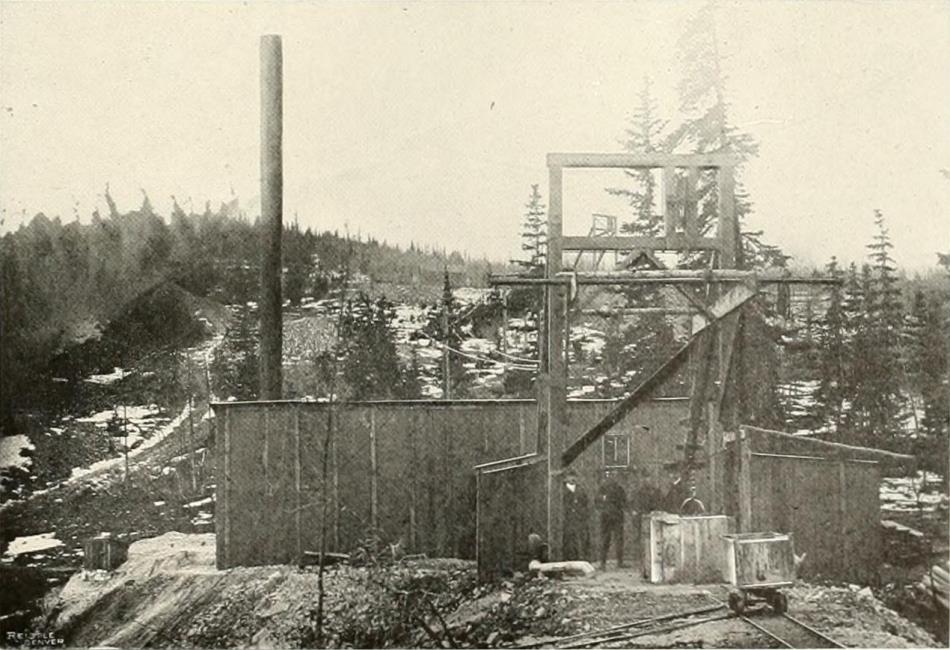 This view of the W. P. H. - also known as the W. H. P. Mine, on Ironclad Hill, eastern slope, show some people posing for the camera. The hoist house and the head frame is clearly visible.