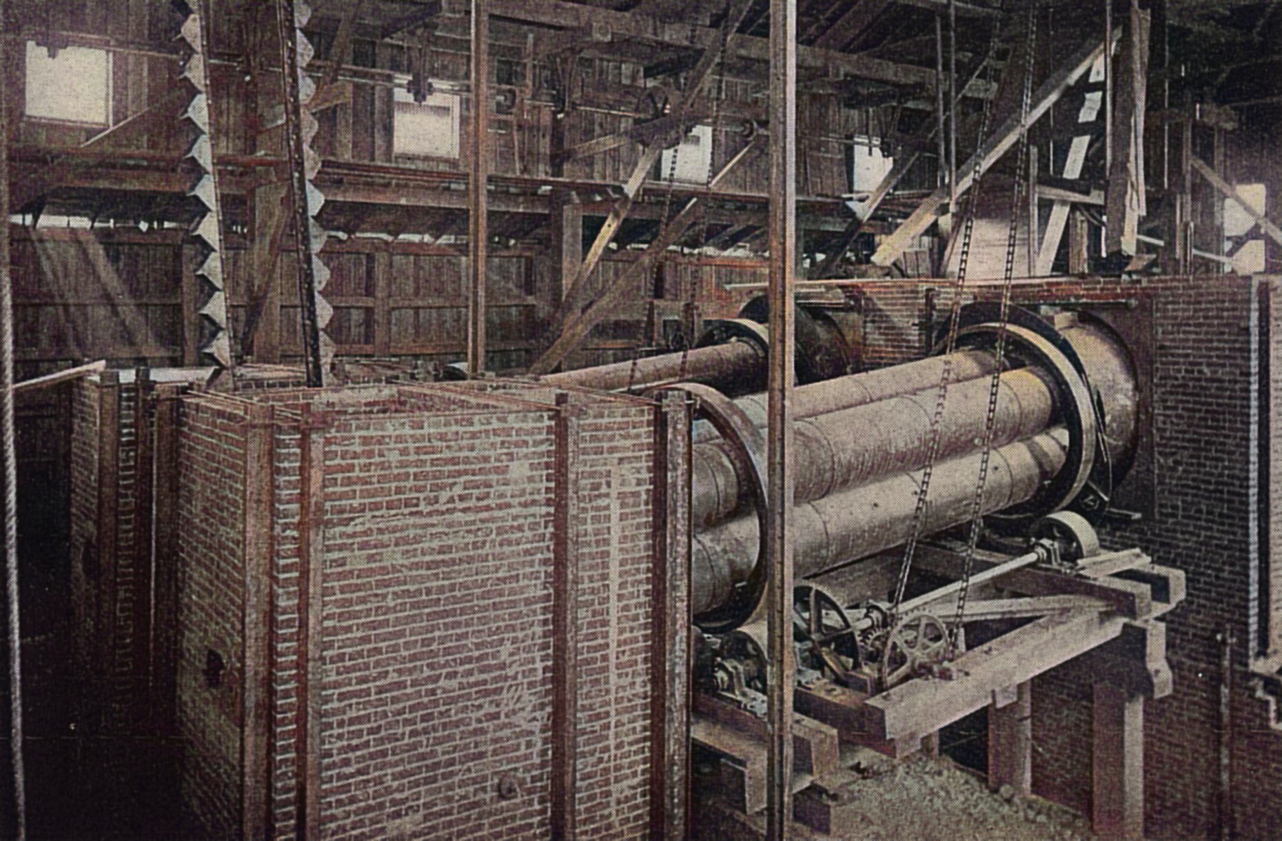 View of the No. 2 dryer while in process of erection at the Metallic Mill. Its capacity was 180 to 200 tons per day. The dryers this mill used back in 1897/98 when this image was taken was of the tubular pattern. The No. 1 dryer consisted of four steel tubes nested together inside two track-bands and connected at the feed and discharge ends by two hoods. The tubes were lined with fireclay tile and revolve as one cylinder.
   As the text this image came with said; ''It will be noticed that the ore is divided into four thin streams and brought into intimate contact with the heated air and gases passing through the 18-in. tubes of the dryer. The motion of the ore advancing in these small tubes is very gentle and regular, and consequently produces but little dust. An improvement in the single cylinder dryer consisted in dividing it into quadrants by plates placed at right angles extending longitudinally through the cylinder. This improvement increased the drying efficiency of the cylinder at the expense of a higher dust loss and greater wear and tear, as the ore is alternately sliding along the plates from the center to the periphery and back to the center again during a revolution of the cylinder. By using four or more small tile-lined cylinders instead of one large cylinder divided into quadrants it was succeeded in again increasing the efficiency and reducing the dust loss and wear at the same time. It will be noticed that this tubular dryer is always in balance, the ore in an ascending tube being balanced by that in a descending one, or very nearly so. The capacity of No. 1 dryer is 80 to 100 tons per day.''
   This seems to have been an invention by Philip Argall and hence it is named 'Argall Drying Furnace'. I did procure the colored version of this image. Source was gray-toned, or in common speech black & white. Used an online service and tweaked and worked with image to get what looks best to my eyes for the moment.