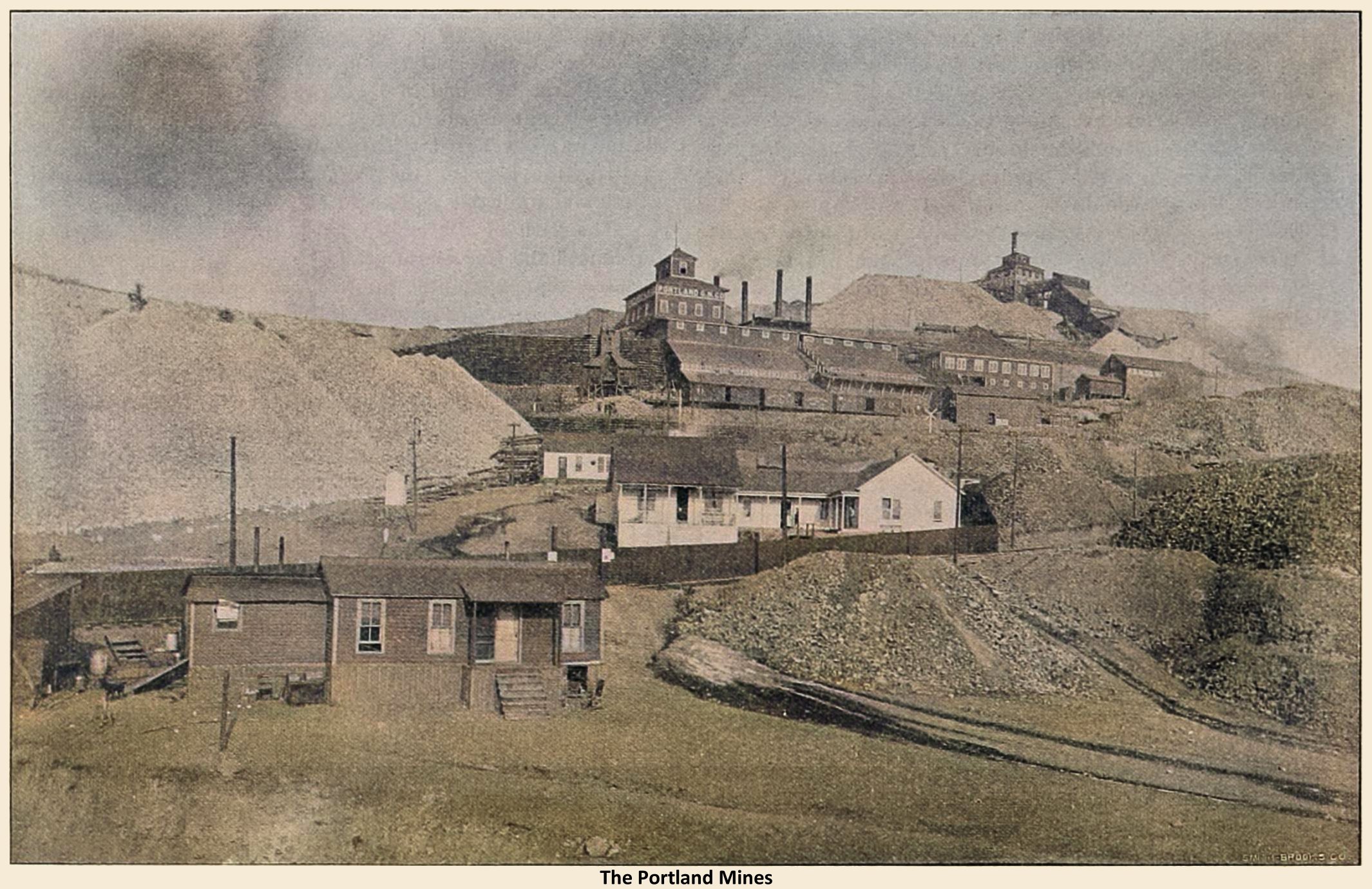 This scene is from 1901 to 1902, as the original High Line is seen in this view, running in front of the darker fence seen about 1/3 up from bottom between the house in front and the houses about center of the view. And in the background, up below the Portland No. 2 Shaft, there is railroad cars seen that belongs to the Short Line Portland Spur, hence, the date is in this timeframe.
  Beside the Portland No. 2 Shaft up against the sky, the huge Portland No. 1 is seen a little bit further down the hill, with railroad cars in front of the many Ore-houses at the mine, and the many structures belonging to the mine.
  I did procure the colored version of this image. Source was grey-toned, or in common speech black & white. Used an online service and tweaked and worked with image to get what looks best to my eyes for the moment.