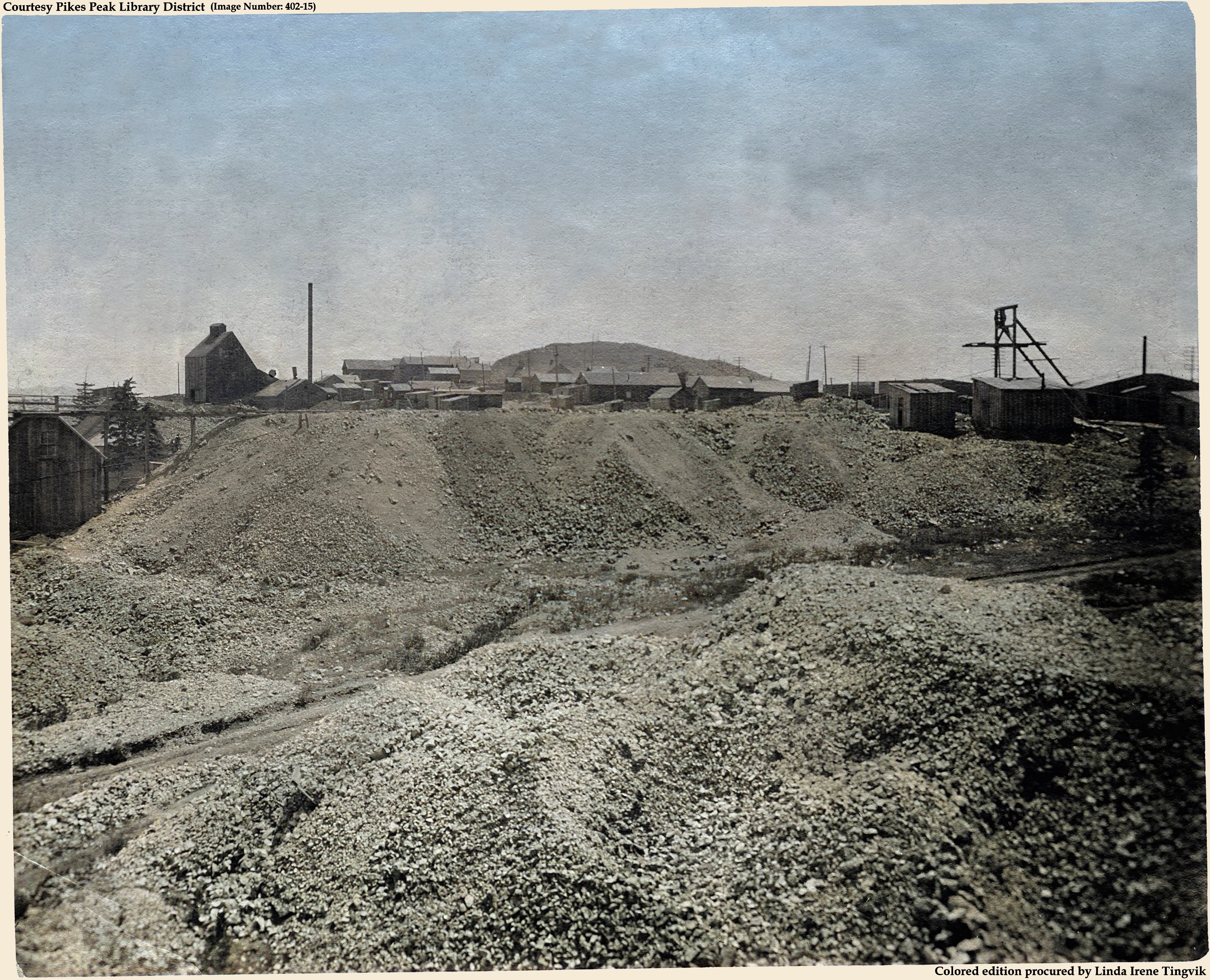 I like this Harlan Photo, even if it has many flaws. I assume this is from before the 1904 Fire that took out the town of Altman, but I really do not know. I do know that this view is taken from northwest of Altman, looking towards Bull Cliff seen as the top sticking up over the houses about center of the view sideways and about 1/3 down from top.
   * At about center top/down at left-hand side is the Orehouse of the Acacia Co. Burns Mine, with a Headframe and structures around that shaft on the right-hand side, and town of Altman houses into the center so to speak.
   * The Pinto Mine Shaft House is seen about 1/3 down from top and about 1/5 in from left-hand side, this is the shaft-house version/look I've seen most often in images/views.
   * The photographer stands on the dumping ground of the northern Pharmacist shaft house, from all I can gather of sources when I write this text November 29, 2021. Source had flaws, made on not good paper, somewhat faded, spots, discoloration, not sharp, but I worked over it as best as I could.
   I did procure the colored version of this image. Source was gray-toned, or in common speech black & white. Used an online service and tweaked and worked with image to get what looks best to my eyes for the moment.