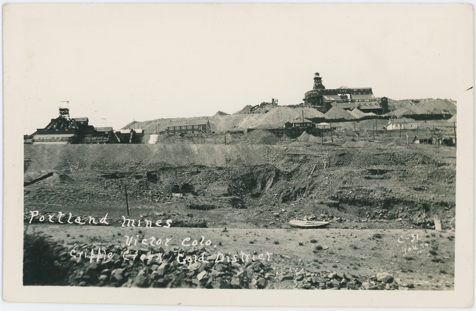 This card has a date of January 25, 1939 written by hand on the backside with a name that appears to say Lester Ropes Jr. below it, but other than that, dating this view is not that easy I feel. There are huge dumps, also it appears to be some sunken earth in the foreground, and two large mine operations with Portland No. 1 – the Burns – Shaft at the left-hand side and the Portland No. 2 Shaft near upper right-hand corner. Huge crib-wall below the No. 2 Shaft hold back massive dumps, I also see several structures further down the slope of Battle Mountain. Sadly, the card is not the sharpest I've seen, and the contrast against the sky is not the best for smaller details, it scanned OK but not great.