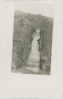 Skagway Dam [Structures Seen at Left Side of a Waterfal Running Into a Dam]